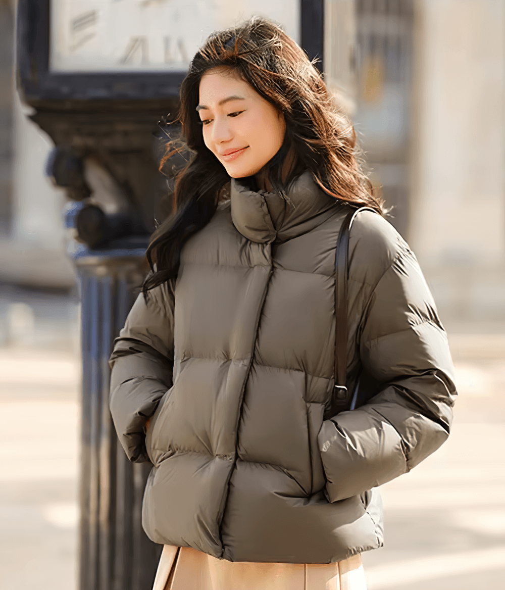 Woman wearing a sleek goose down jacket with stand-up collar, perfect for casual winter style.