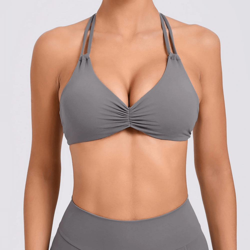 Women's halter push-up sports bra in grey for high-impact activities with breathable and quick-drying fabric.