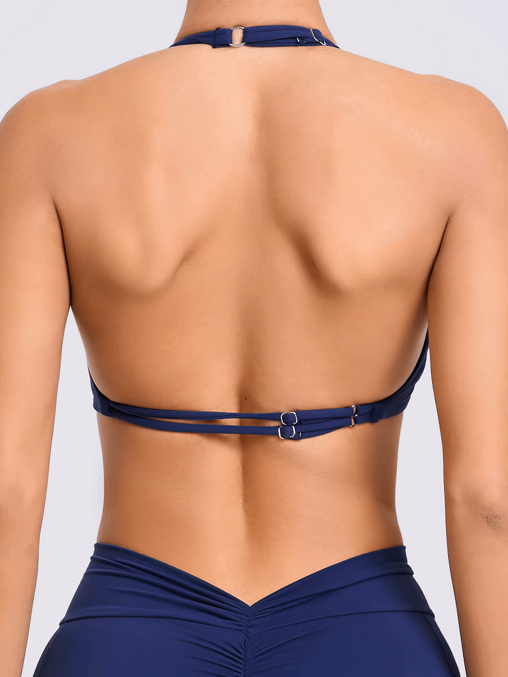 Rear view of a navy blue women's halter push-up sports bra, open-back design for enhanced airflow, perfect for high-impact activities.