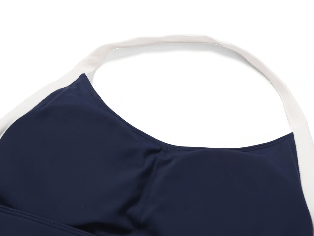 Close-up of women's halter sports bra with contrast trim, navy color, offers stylish activewear option with light support for yoga and workouts.