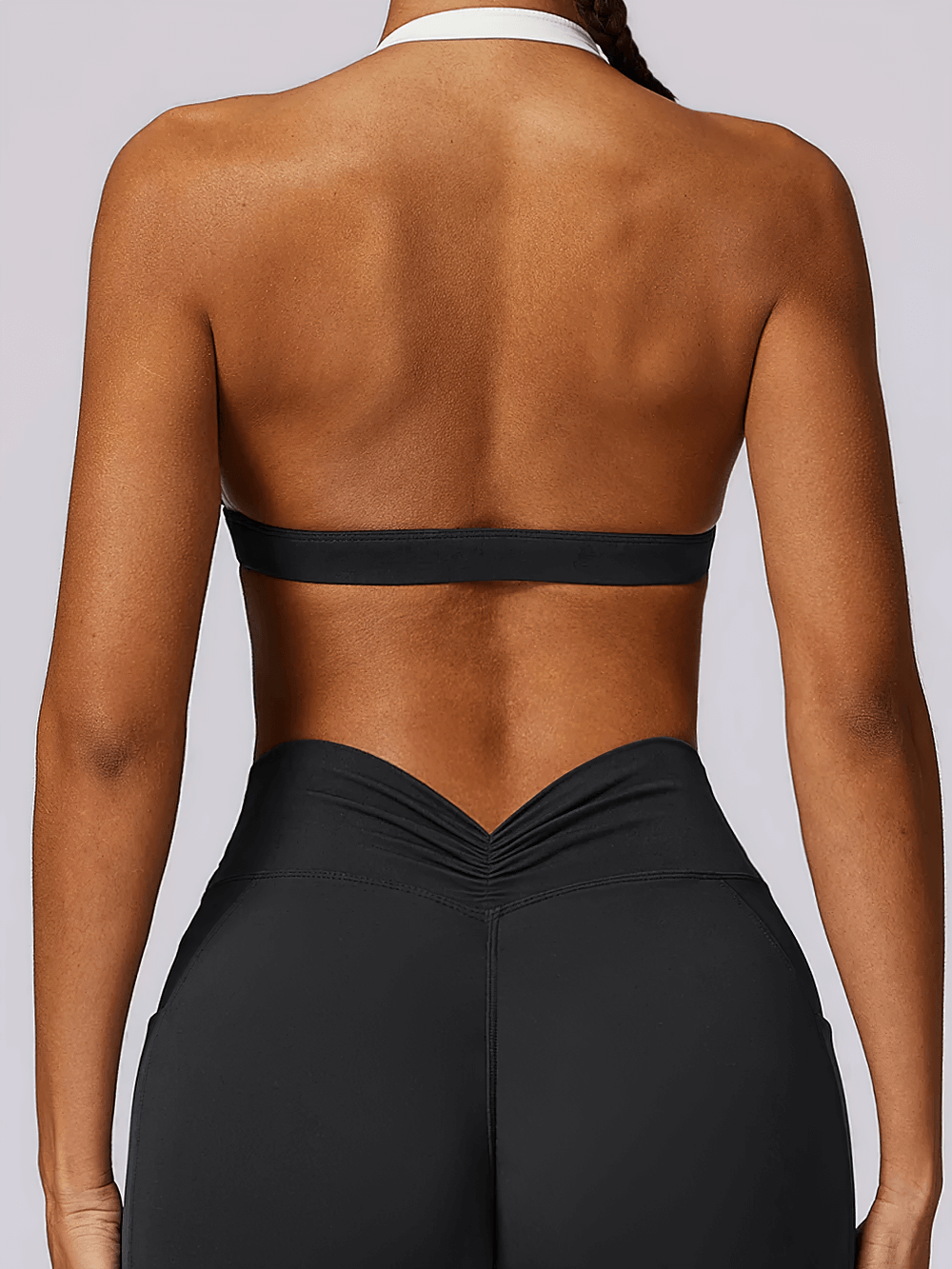 Back view of women's halter sports bra with contrast trim, showcasing modern design and breathability for yoga and light workouts.