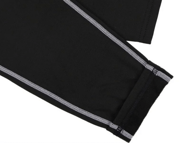 Close-up of black high-waist insulated yoga leggings with stitching detail, highlighting soft stretchable polyester fabric.
