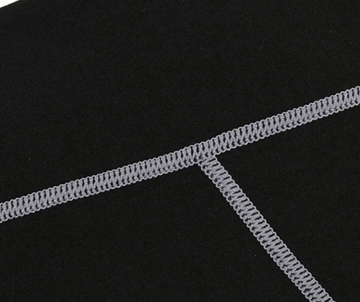 Close-up of grey stitching on black high waist insulated yoga leggings, showcasing durability and design details.