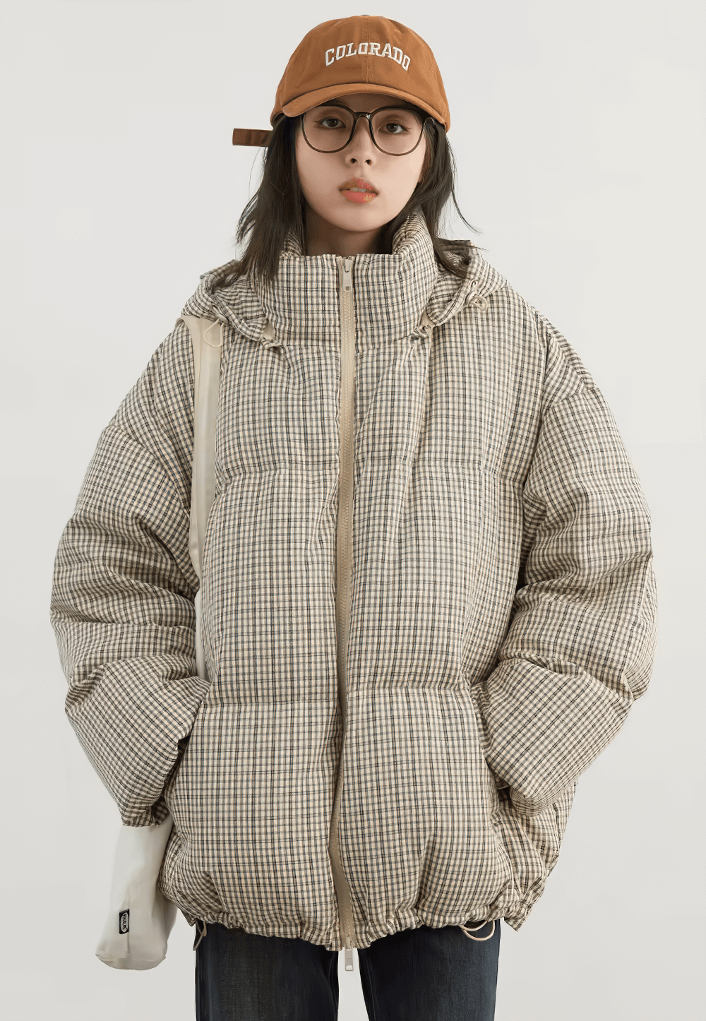 Women's hooded plaid down jacket with duck down, perfect for cold weather. Stylish winter coat with zipper closure. Model wearing jacket.