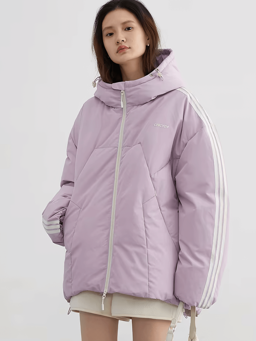 Woman wearing a purple hooded down jacket with white stripes, showcasing a loose-fitting, stylish winter streetwear look.