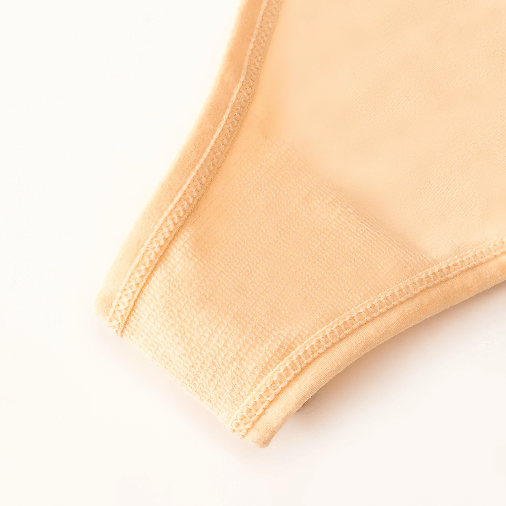 Close-up of women's lace-up low-rise thong panties in a soft beige color, showcasing detailed stitching and sleek design.