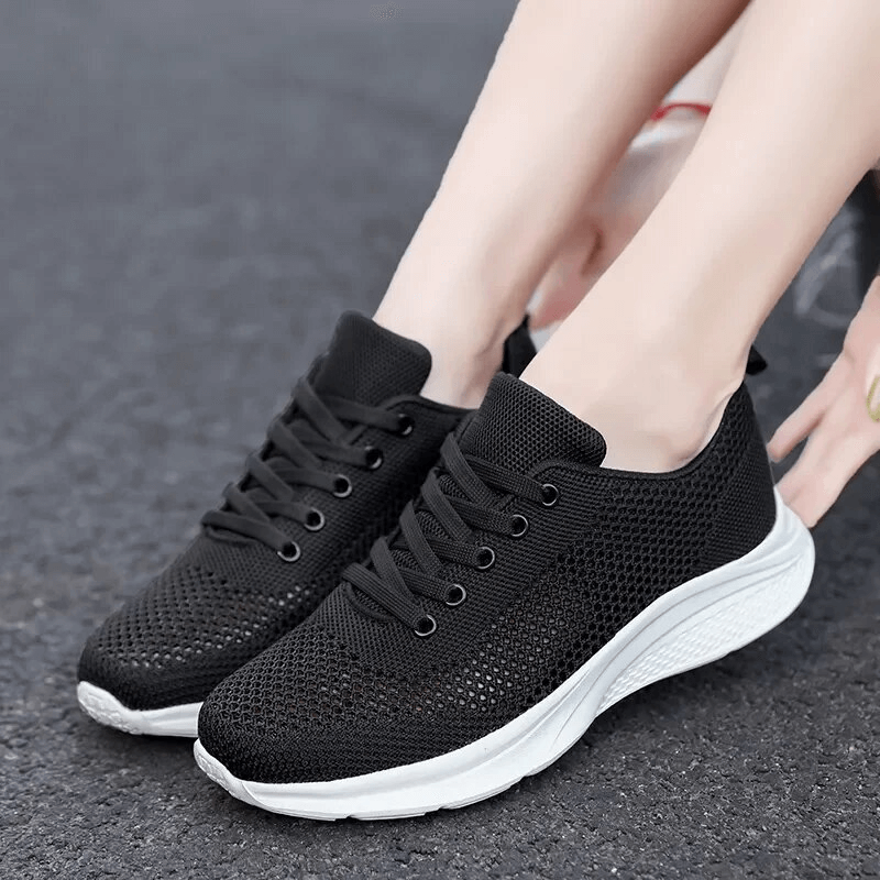 Woman wearing black lace-up mesh breathable walking tennis shoes, style SF1710, with white PVC outsole, perfect for comfort and stability.