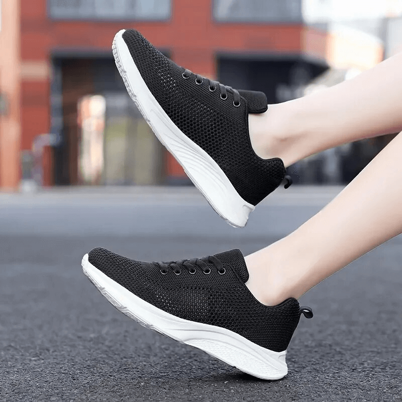 Women's black lace-up mesh breathable walking tennis shoes, lightweight and stylish on urban street.