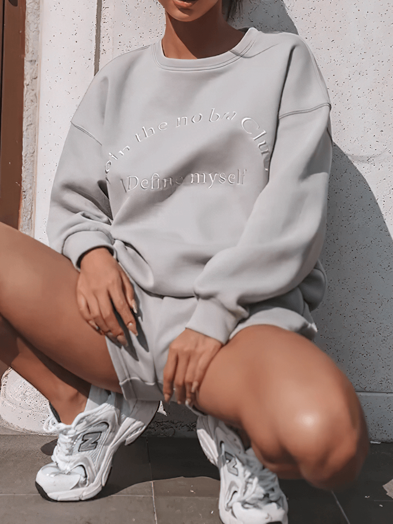 Women's solid color sweatshirt and shorts set with letter embroidery, showcasing a casual and chic style, ideal for outdoor wear.