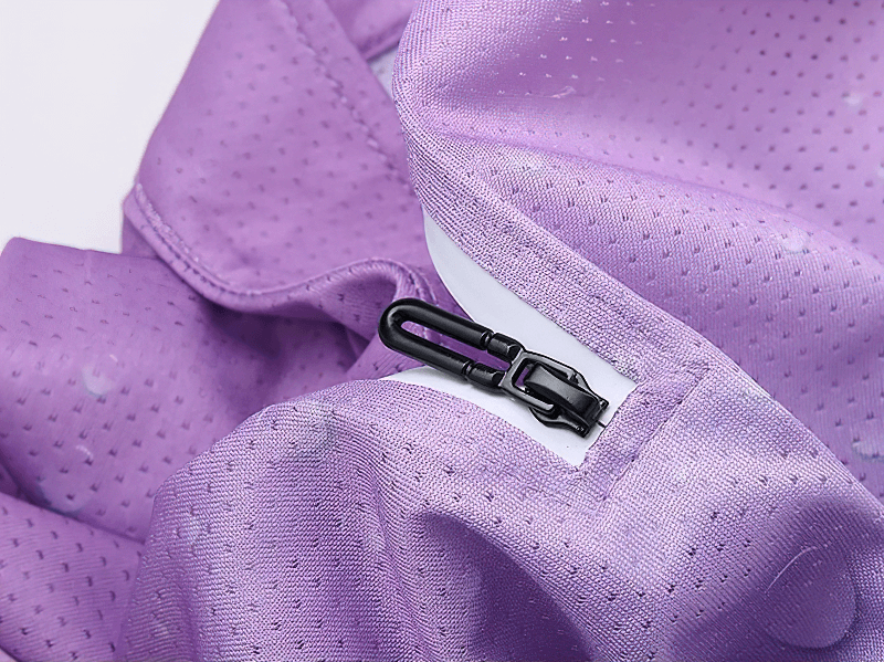 Close-up of purple ice silk fabric with zipper detail and perforated pattern for breathable comfort.