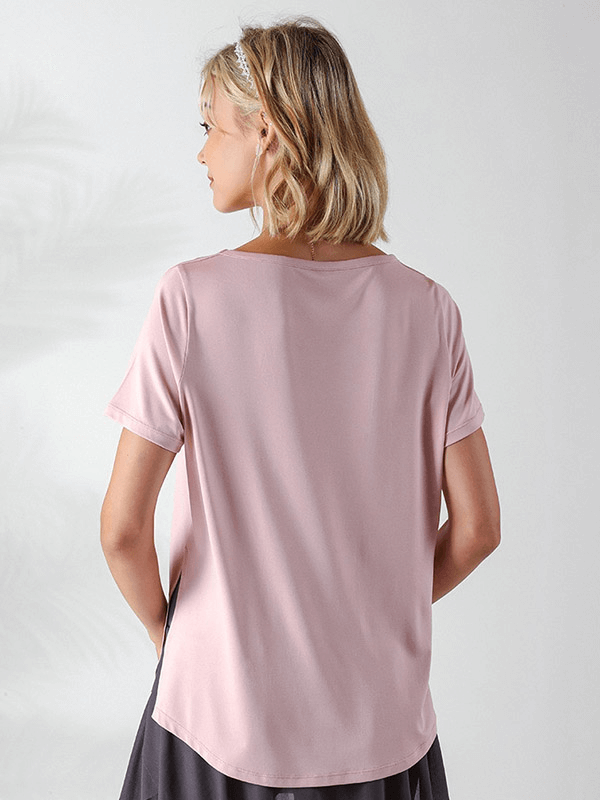 Woman wearing pink loose t-shirt with hollow-out shoulders, ideal for running and yoga, showcasing breathable and wrinkle-resistant fabric.