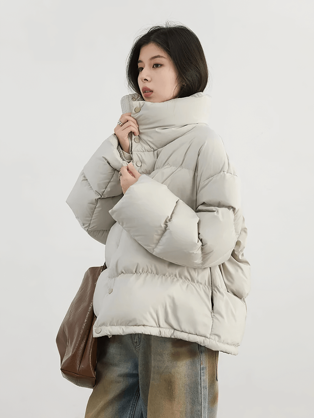 Woman wearing a women's loose stand collar duck down winter jacket, showcasing chic winter style with warmth and comfort.