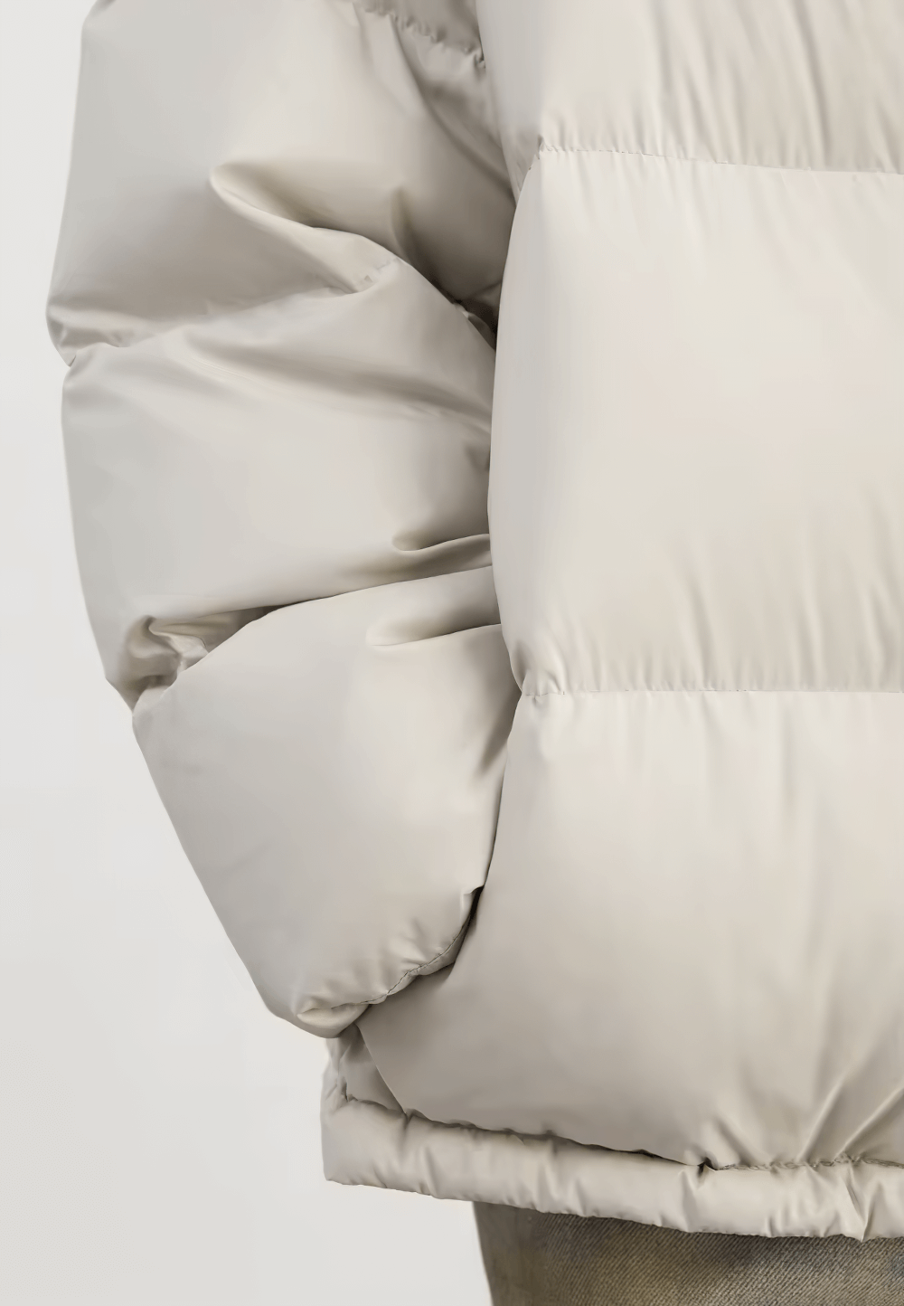 Close-up of a women's loose down winter jacket, showcasing its puffy texture and light color. Perfect for cozy, stylish winter wear.