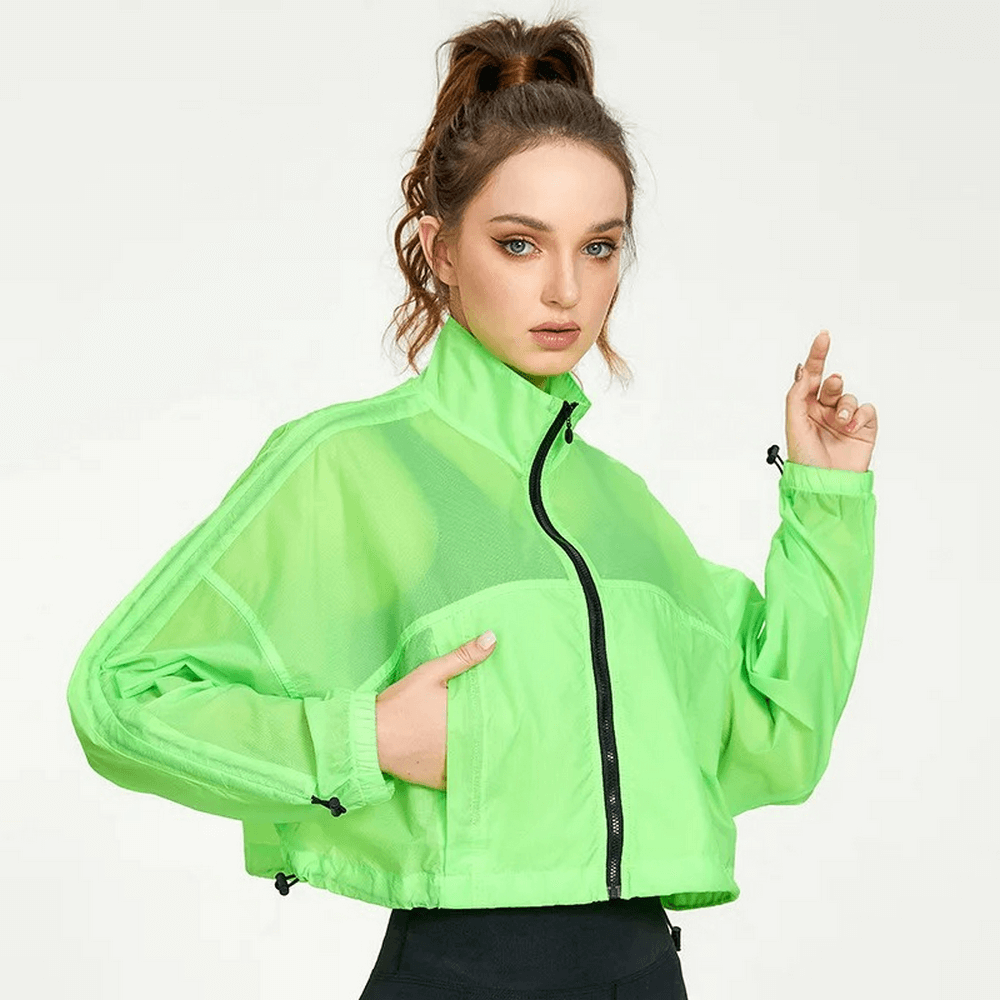 Woman wearing neon green windbreaker jacket with full sleeves, sporty and stylish design, perfect for outdoor activities.