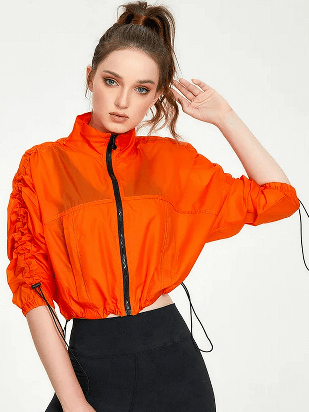 Vibrant neon orange women's windbreaker jacket with full sleeves, showcasing stylish and breathable design for activewear.