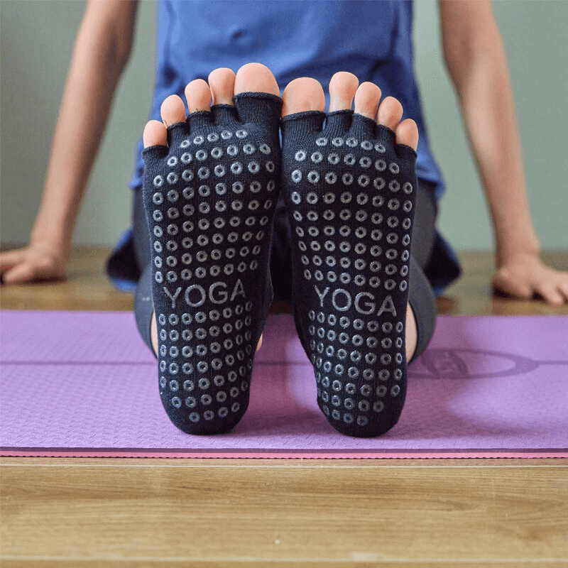Non-slip breathable five-toe yoga bandage socks on mat, perfect for female yogis. Anti-pilling, antistatic, with super elasticity.
