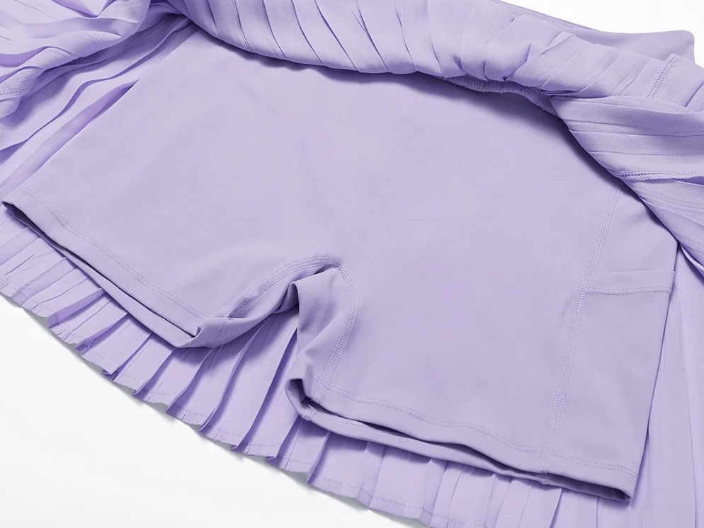 Purple pleated women's tennis skort with integrated shorts, ideal for athletic performance and style on the court.