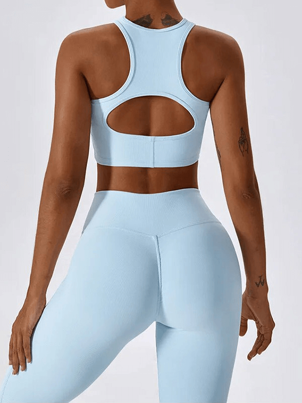 Back view of woman in light blue push-up sports bra and ribbed leggings, showcasing sleek, breathable activewear design.