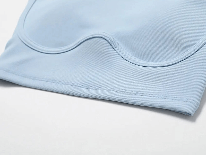 Close-up of light blue ribbed push-up sports bra, highlighting breathable, quick-dry fabric for active lifestyle.