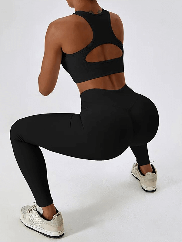 Woman squatting in black push-up sports bra and ribbed leggings, showcasing activewear's fit and flexibility.