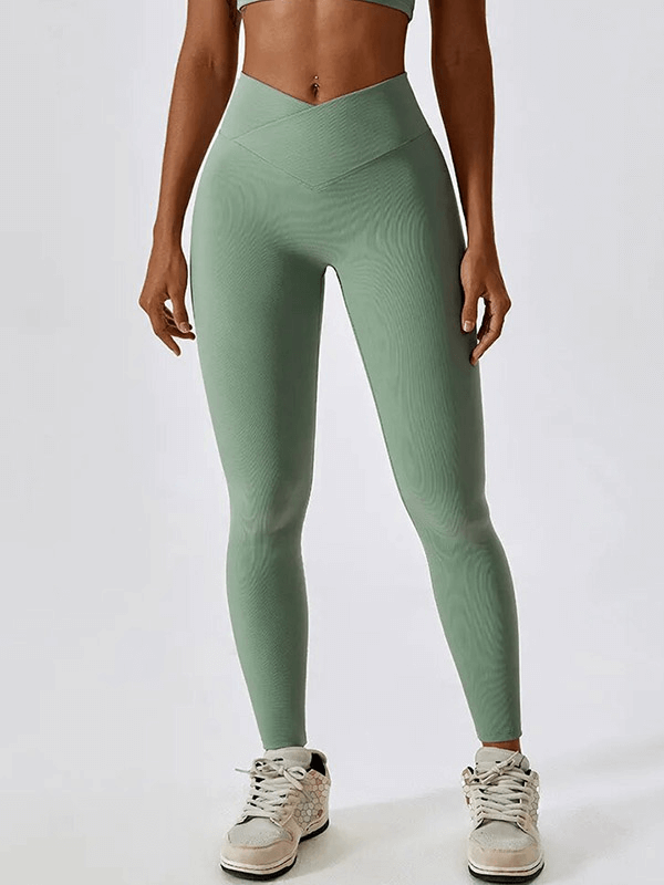 Model wearing seafoam green ribbed cross leggings perfect for active lifestyle, showing stretch and comfort.