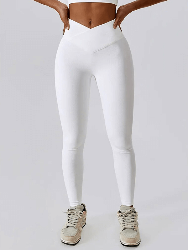 Woman wearing white ribbed cross leggings for an active lifestyle, showing stylish design and comfort with sneakers.