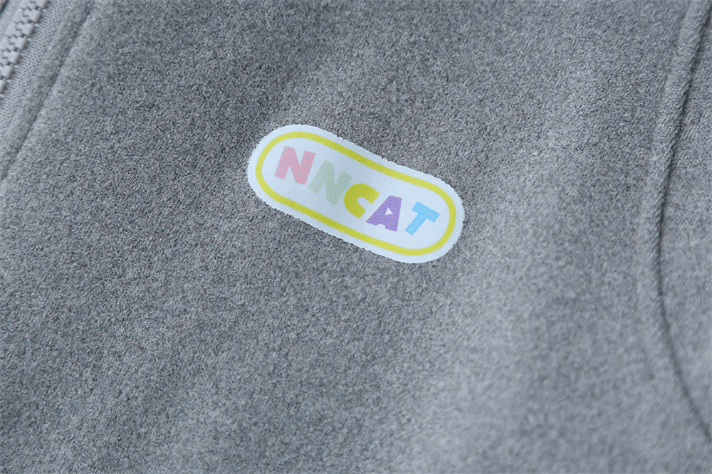 Alt Tag: Women's Quarter Zip Hooded Sport Hoodie - SF4536 grey fabric close-up with colorful NMCAT logo patch