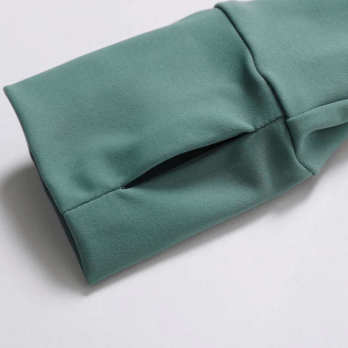 Close-up of green sleeve with zipper on women's quick-drying yoga shirt for adjustable ventilation and comfort