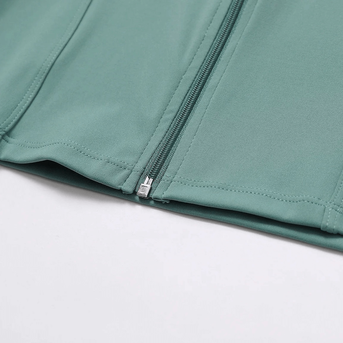 Close-up of women's quick-drying yoga shirt with zipper in green, showcasing breathable nylon fabric for comfort.