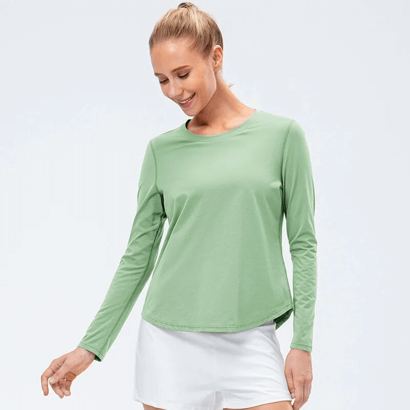 Woman in green quick-drying long-sleeve sports top for yoga, featuring a loose fit for comfort and movement.