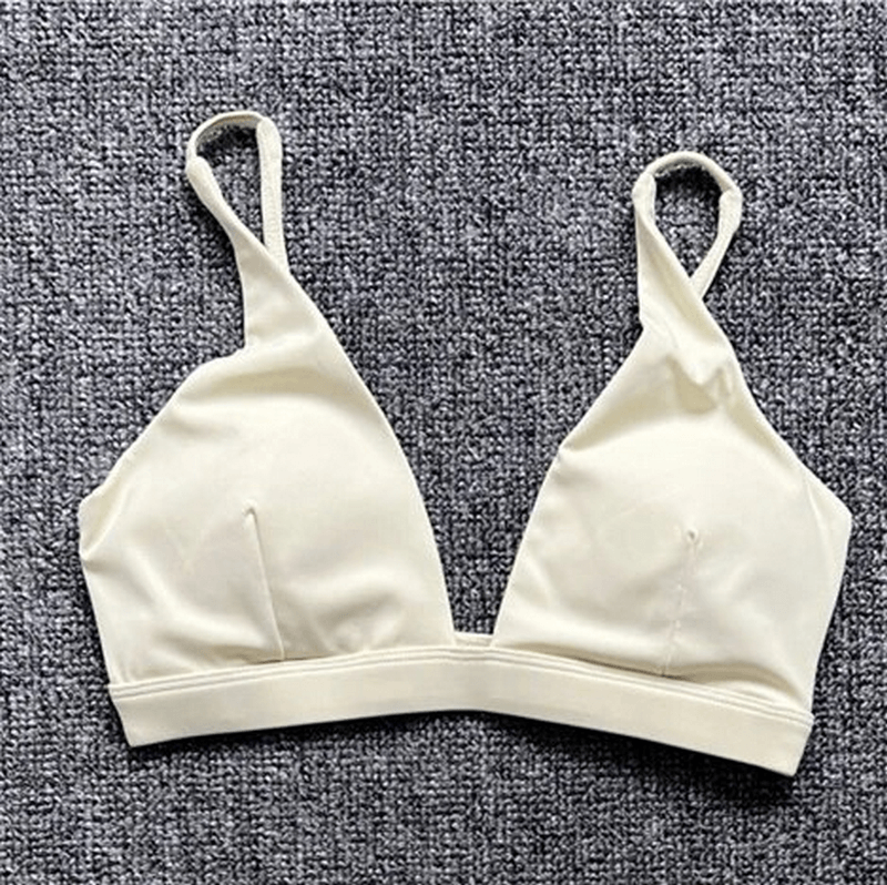 Women's quick-drying sports bra with deep neckline in solid beige, perfect for yoga and workouts. Nylon, breathable support.
