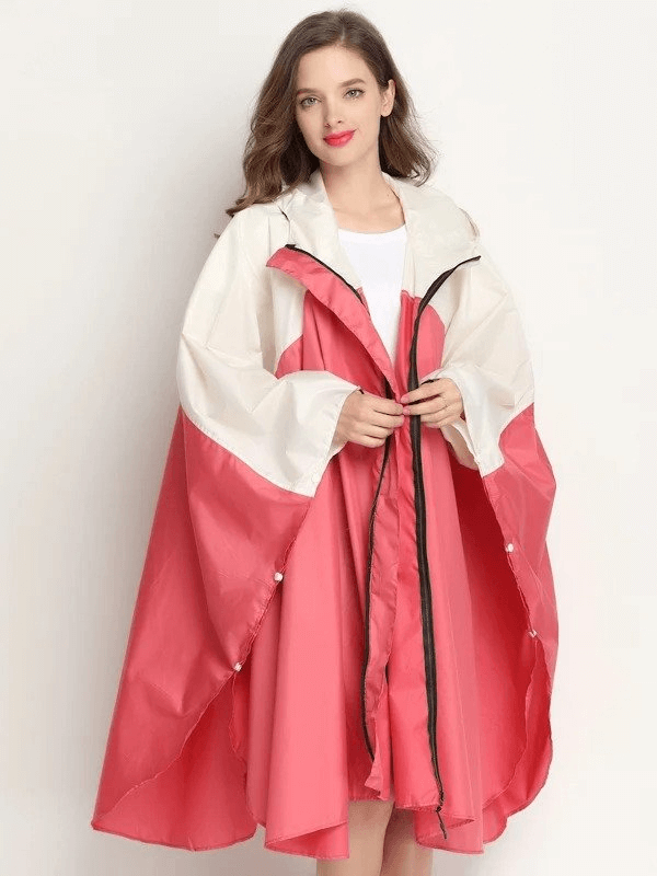 Fashionable women's raincoat-poncho with zipper and hood, showcasing pink and white design, perfect for rainy days and wind protection.