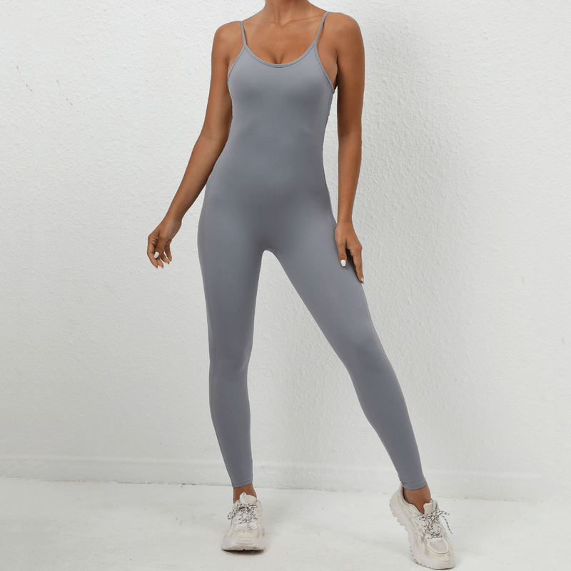 Woman in grey seamless fitness jumpsuit with sexy back, straps, and ankle-length leggings, perfect for exercise. Model SF1290