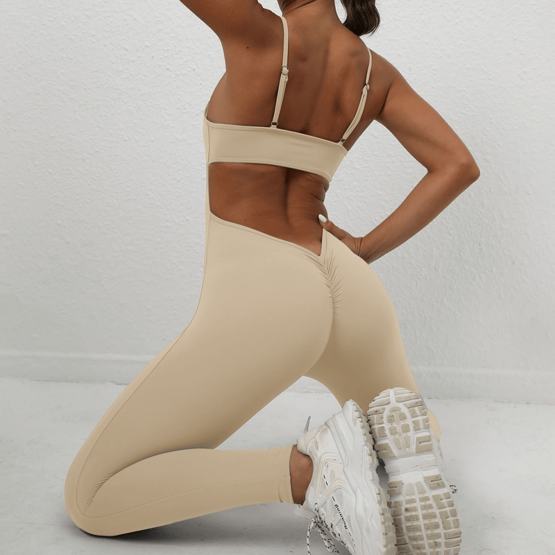 Woman wearing seamless fitness jumpsuit with sexy back and straps, showcasing a confident look and ankle-length leggings.