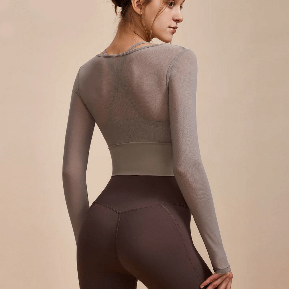 Woman wearing seamless long sleeve yoga crop top SF2112 showcasing trendy sportswear. Breathable and quick-dry for active lifestyle.