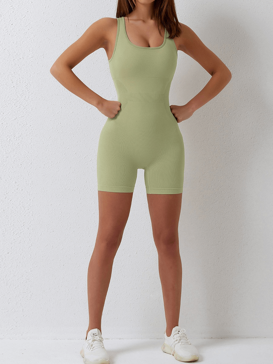 Woman wearing a sexy back sleeveless one-piece green jumpsuit, perfect for yoga and fitness, showcasing slim fit and comfort.