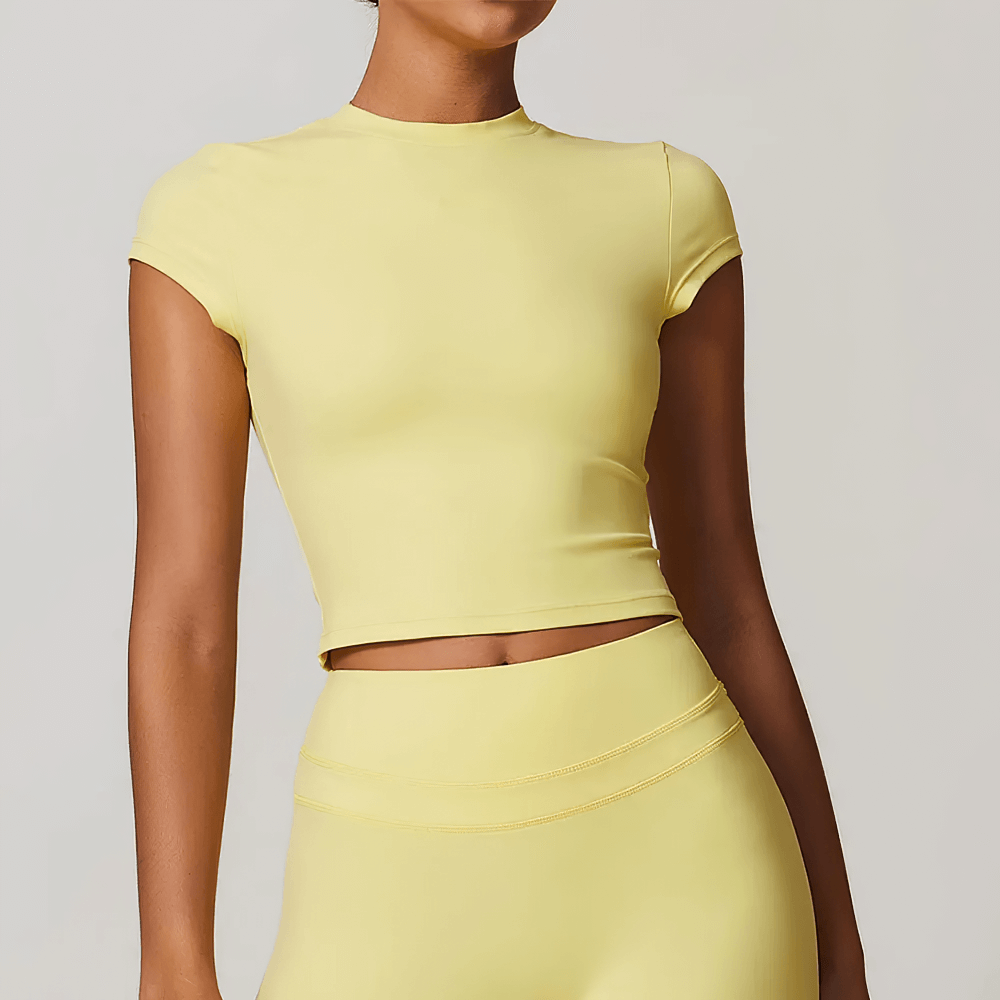 Woman wearing a yellow short sleeve fitness t-shirt, perfect for yoga and workouts, made from anti-pilling and quick-dry fabric.