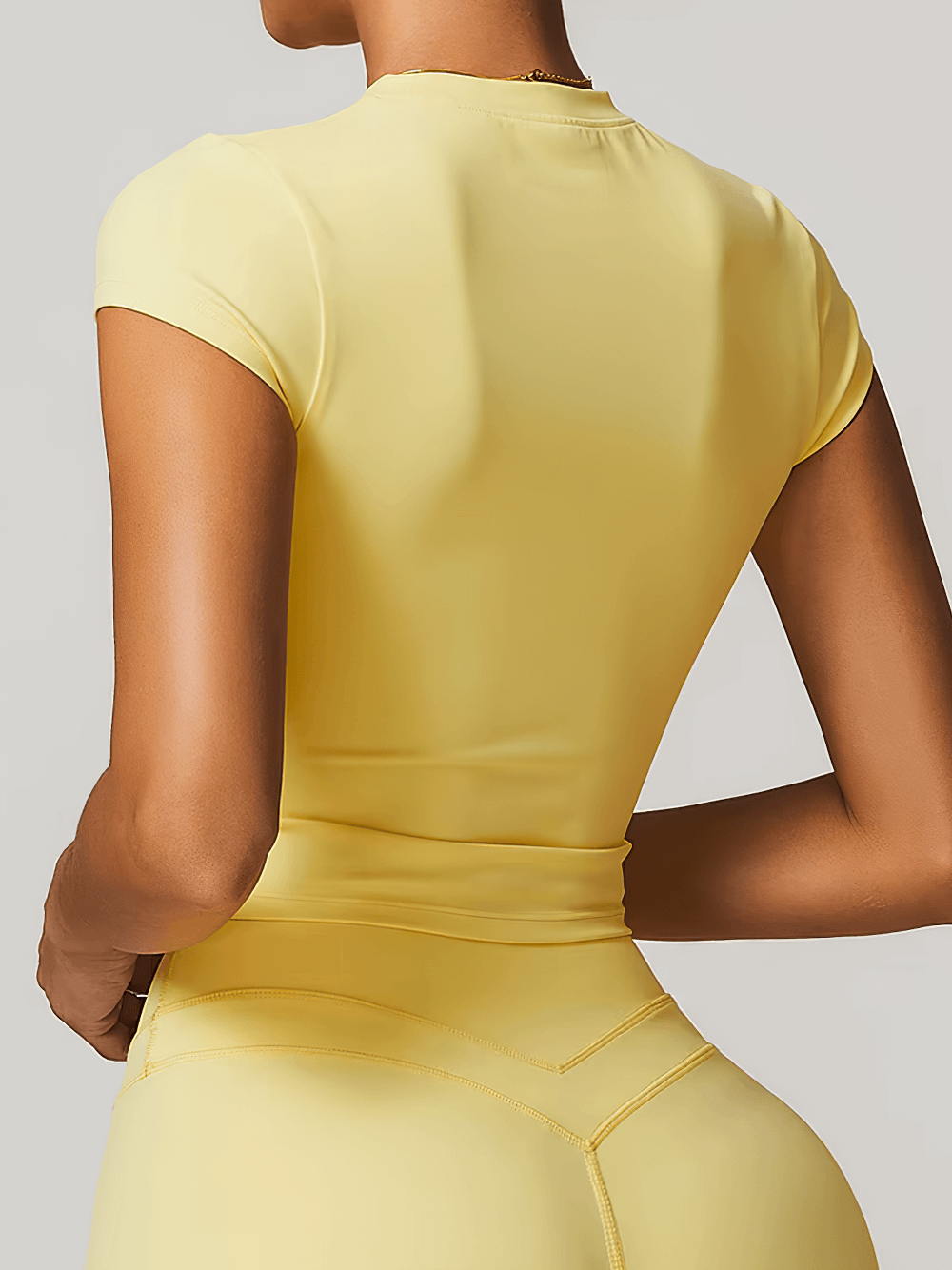 Back view of a yellow women's short sleeve fitness T-shirt ideal for yoga, running, and hiking with quick-dry and breathable fabric.