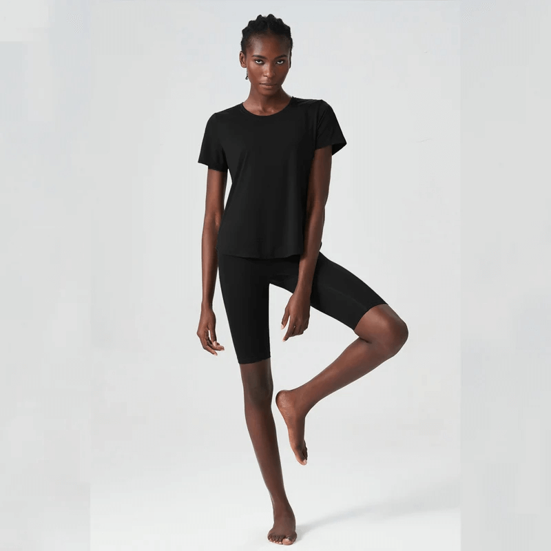 Woman in black solid color yoga set SF2079, featuring breathable Lycra and anti-shrink properties, ideal for workouts.