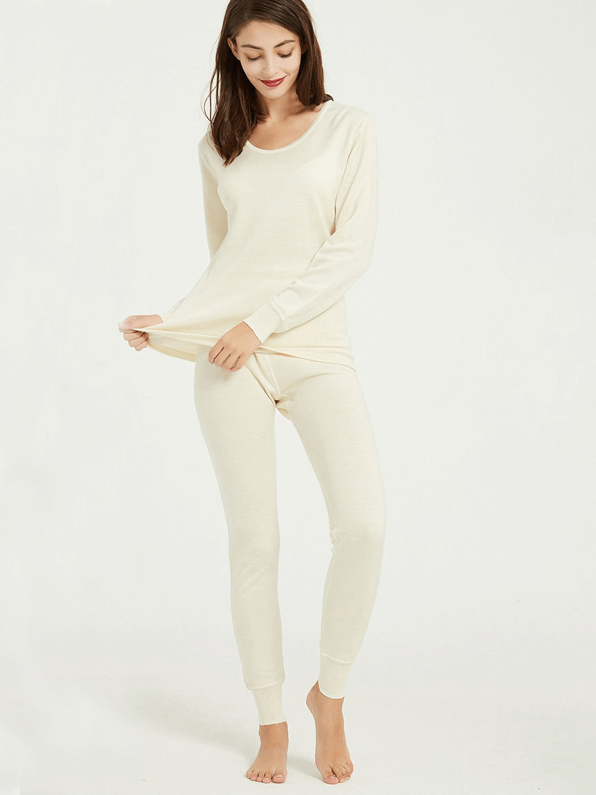 Woman wearing solid color wool thermal underwear set, showcasing warm mid-rise Merino wool base layer for winter.