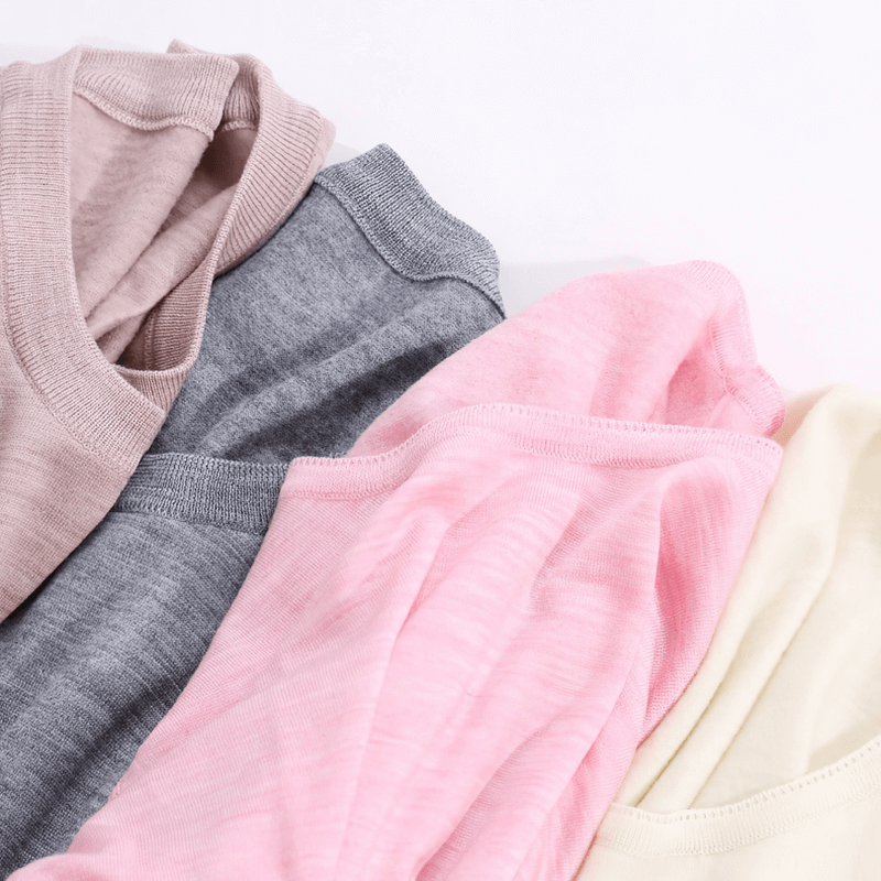 Women's solid color wool thermal underwear set in pink, beige, and grey shown close-up; perfect for winter warmth and comfort.