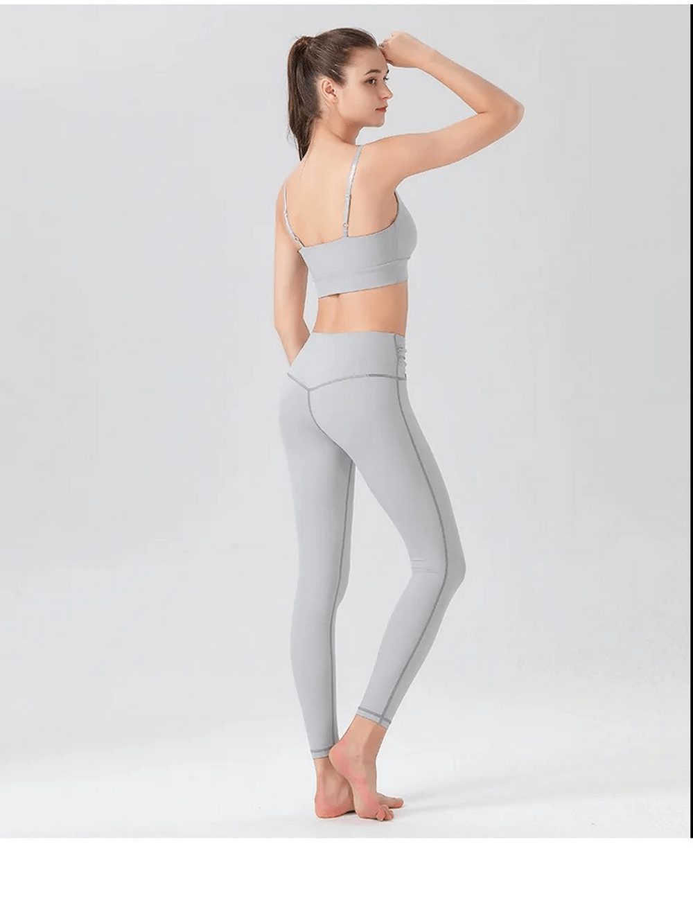 Woman wearing grey spandex workout two-piece set with sleeveless top and leggings for yoga or fitness activities, SF2120.