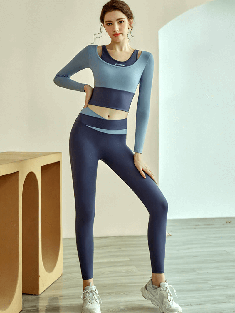 Woman wearing a blue sports long sleeves crop top and leggings, perfect for fitness training and active lifestyle.