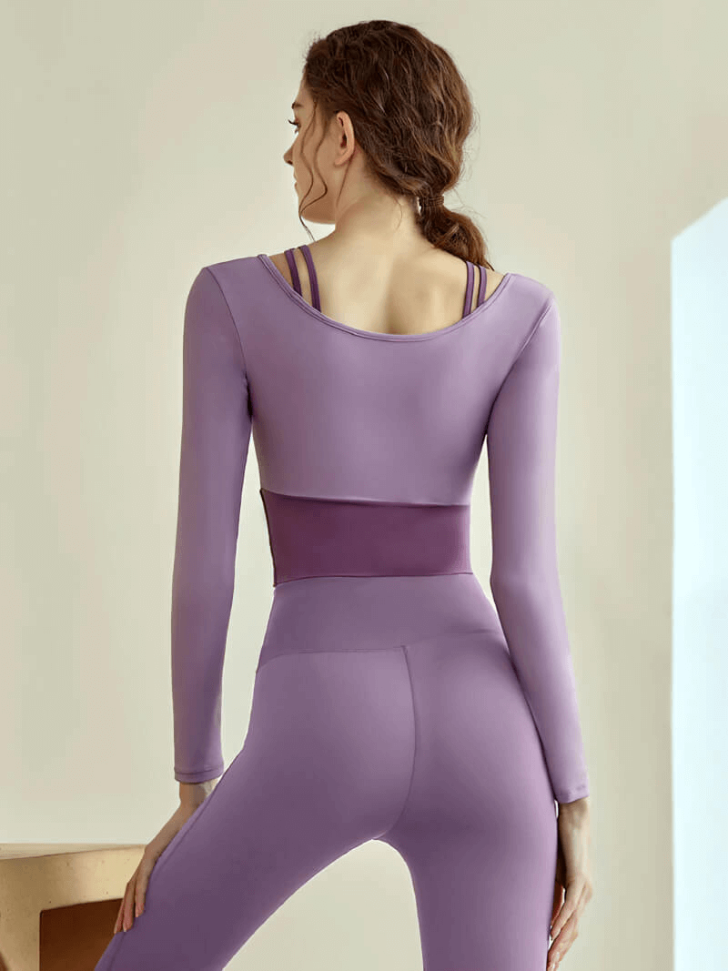 Back view of a woman in a purple long sleeves crop top and leggings, designed for fitness training with nylon-spandex blend - SF0094