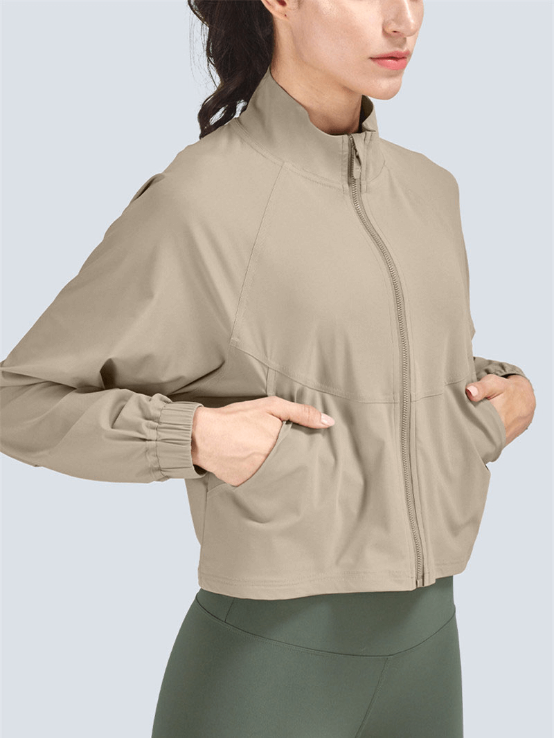 Woman wearing beige stand collar zipper loose short jacket, ideal for casual sports. SF1448, 77% nylon+23% spandex blend.