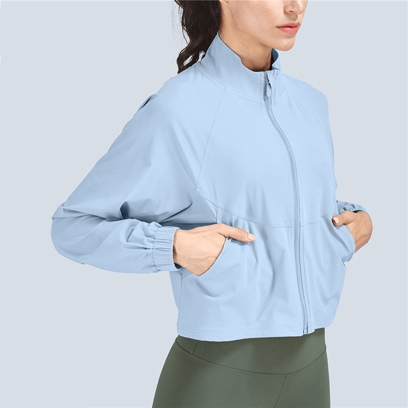 Light blue women's stand collar zipper short jacket, perfect for casual sports. Made from breathable nylon-spandex blend for comfort.