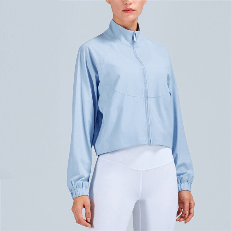 Woman wearing light blue stand collar zipper loose short jacket, perfect for casual sports or leisure activities.