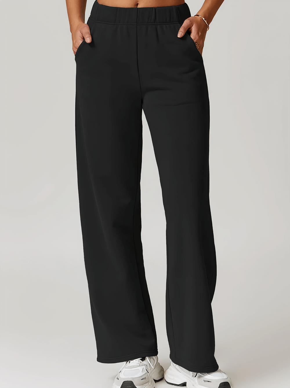 Women's high-waist straight-leg sweatpants in black, perfect for casual winter sports or lounging, featuring practical pockets.