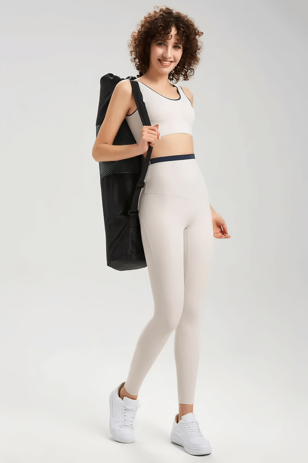 Woman in seamless yoga sports bra and leggings, carrying yoga mat. Perfect breathable and stretchy attire for fitness and running.