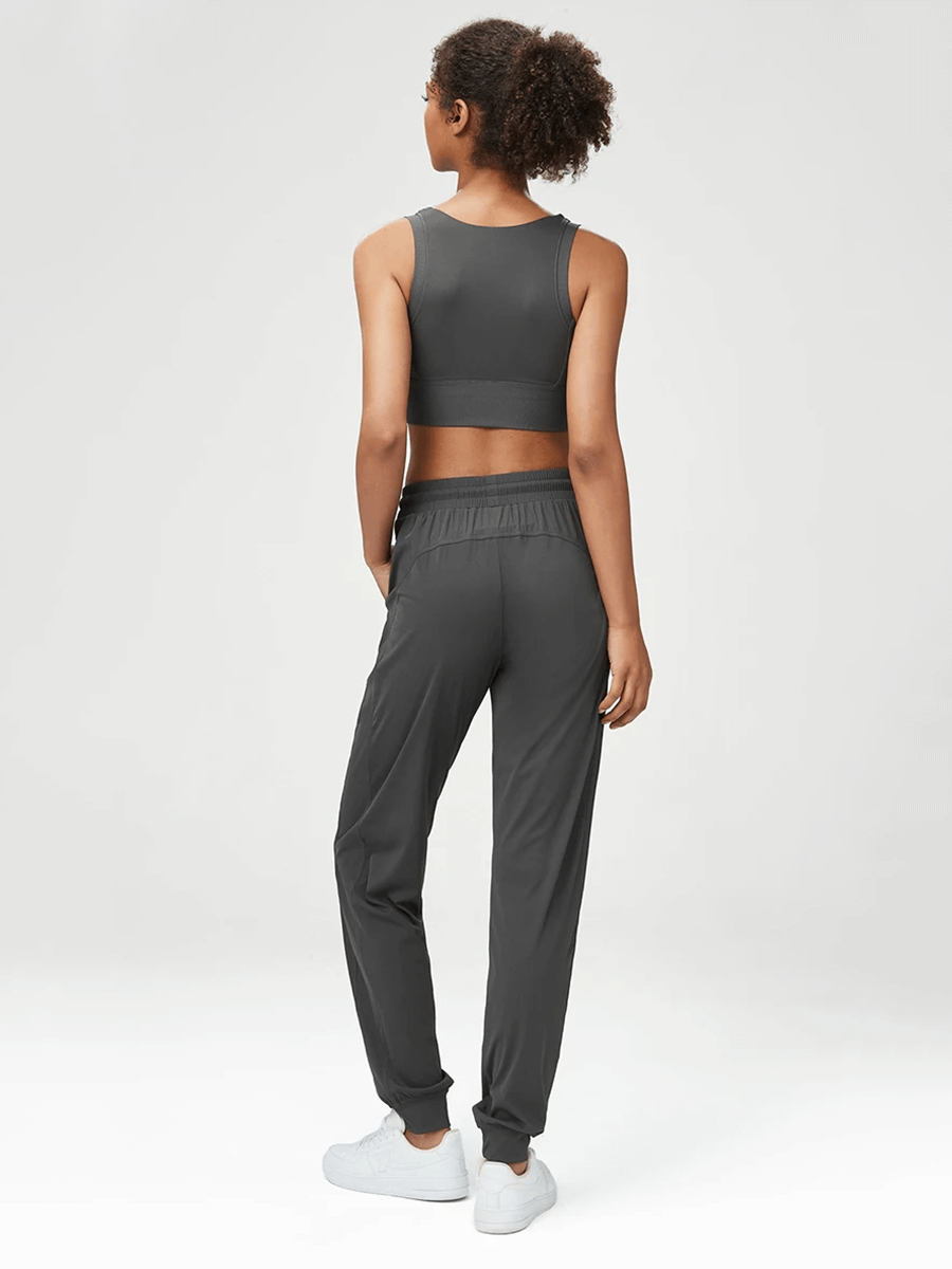 Women's stylish gray joggers and sports bra set, featuring breathable fabric and a relaxed fit for both active and casual wear.